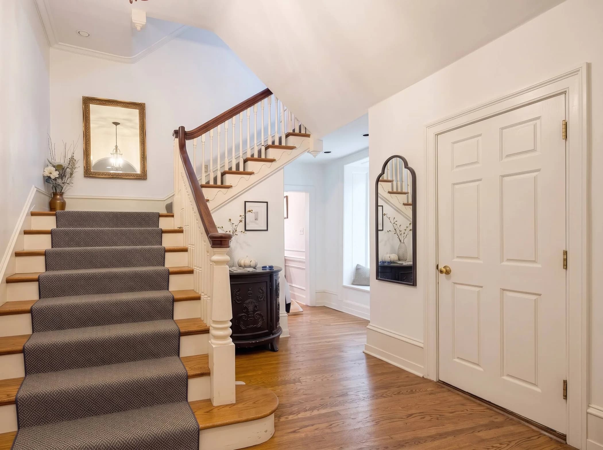 The main staircase at The Rittenhouse Residence, with its red runner and handrail