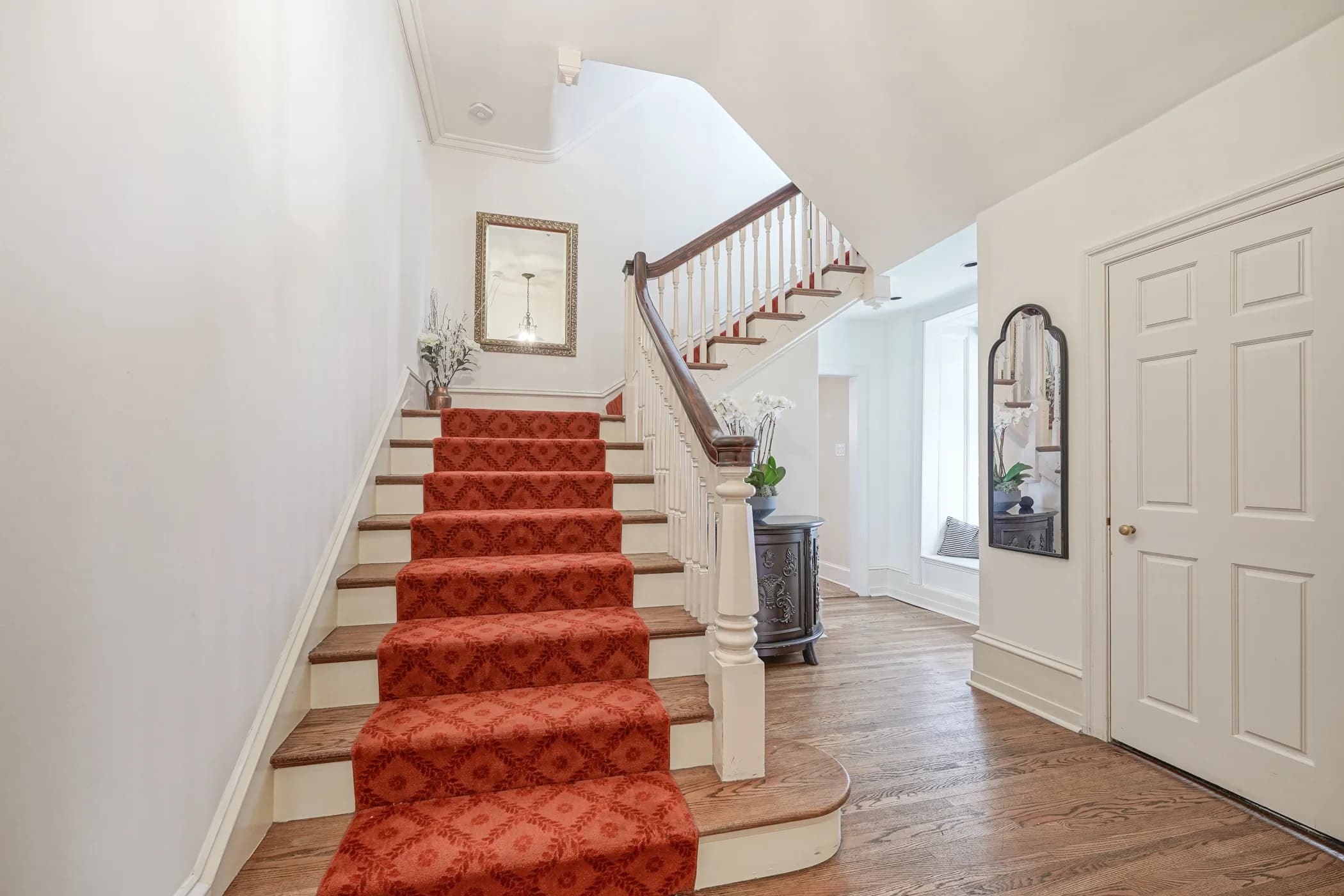 The main staircase at The Rittenhouse Residence, with its red runner and handrail